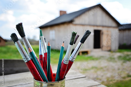 pencils and brushes on open air painting in the village