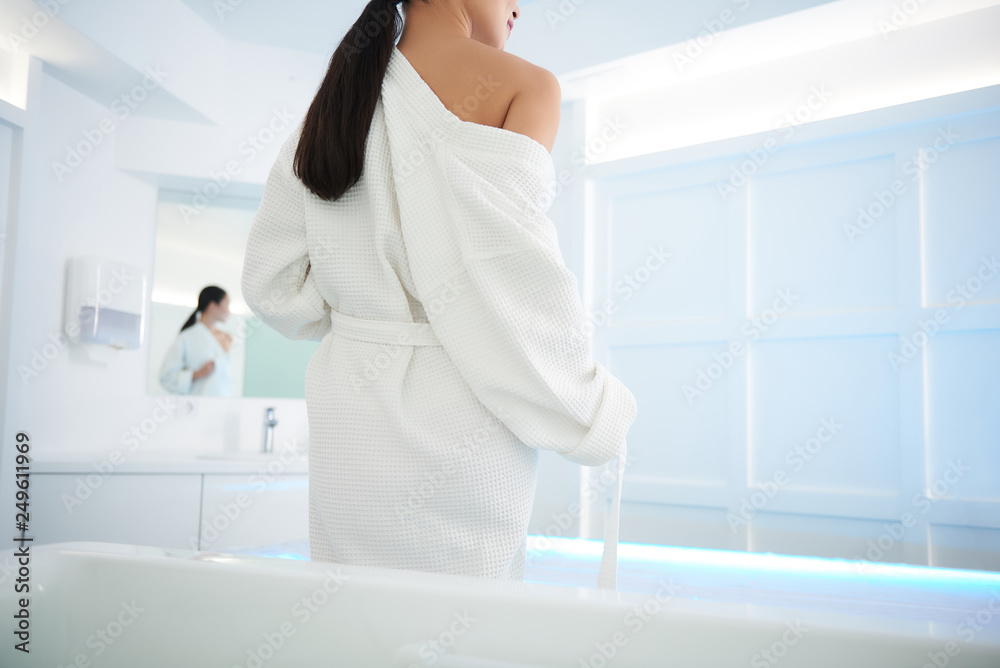 Lady put her bathrobe off before bath procedure Lady put her bathrobe off before bath procedure