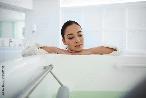 Careful asian lady lean on bath in beauty salon