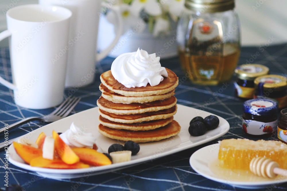 Breakfast pancakes served with honey and fruits Breakfast pancakes served with honey and fruits