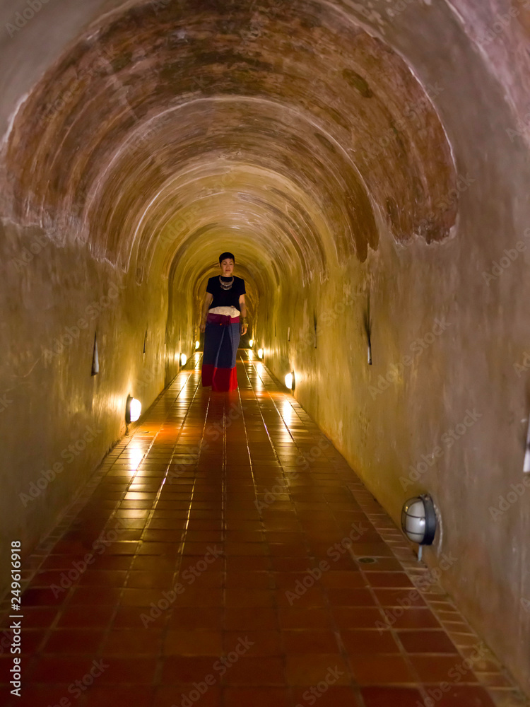 Femme en habit Thaï trditionnel dans le temple souterrain du Wat Umong