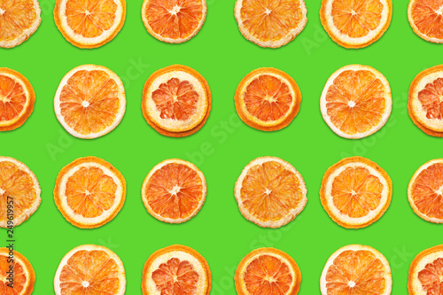 Cut orange fruit sections. Slices pattern design isolated on green background. 
