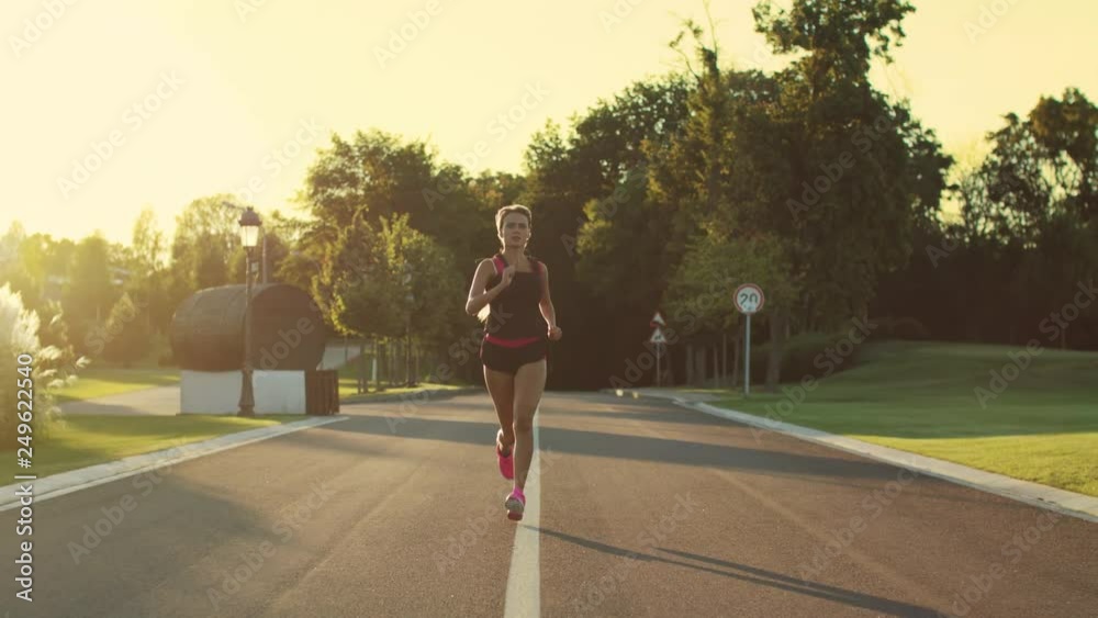 Sport woman running in park at sunset. Female runner training run outdoor