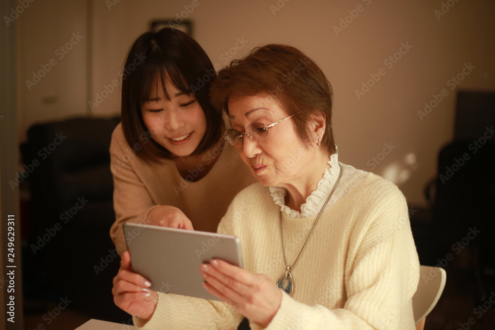 タブレット端末の操作を教わるシニア女性 タブレット端末の操作を教わるシニア女性