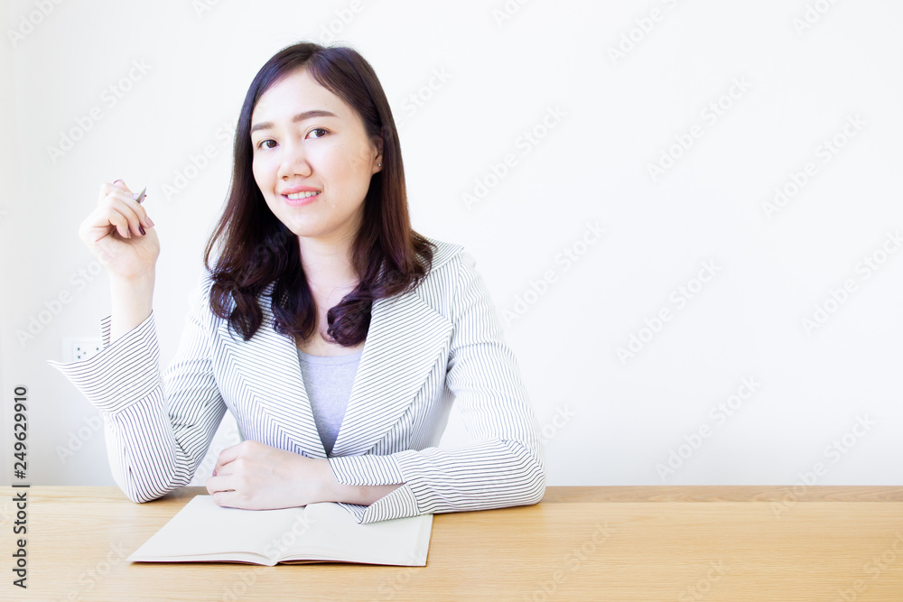 Portrait of Asian business women sitting on the wooden table in the office. Portrait of Asian business women sitting on the wooden table in the office.