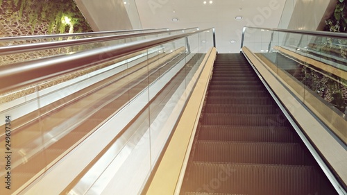 Shopping Mall Interior with Empty Escalators and No People Around. Modern Staircase Escalators and Fashion Shops Image.