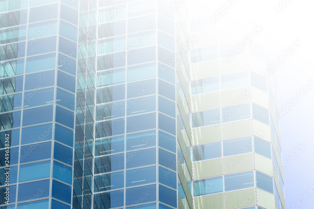 White copy space flare over modern building facade in glass and metal. New construction highrise buildings for business and finance. White copy space flare over modern building facade in glass and metal. New construction highrise buildings for business and finance.