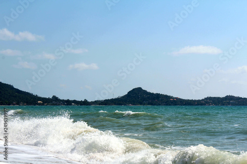 Tropical paradise - the coast with beautiful white waves against the blue sky. Thailand, Samui Island