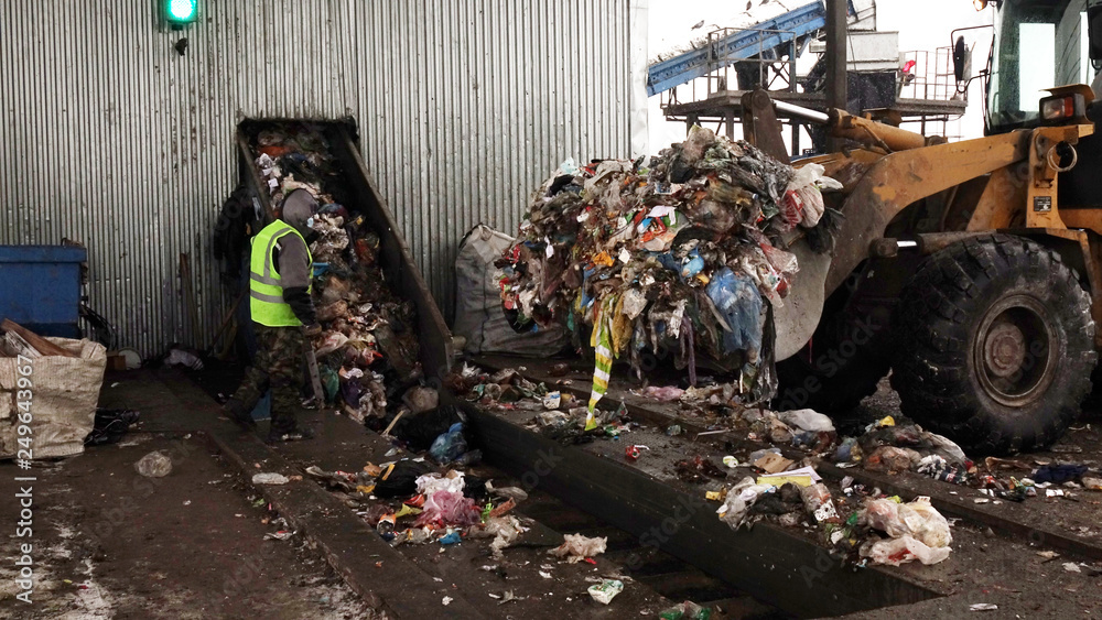 Obraz premium Workers at the waste processing plant. Sorting trash on a conveyor belt.