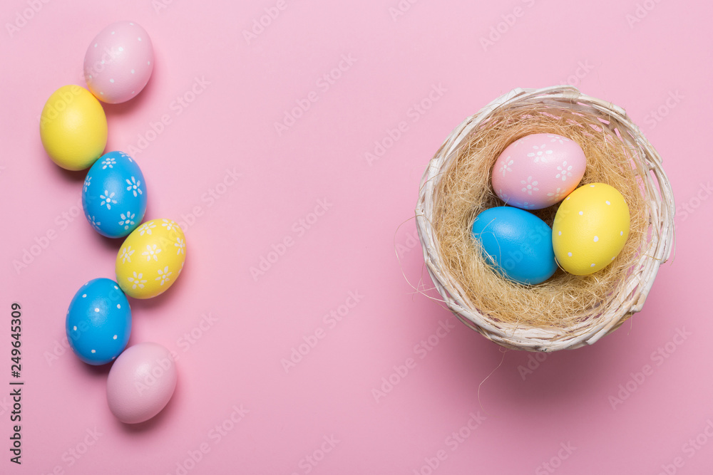 Colorfull easter eggs in nest on pastel color background with space. Concept