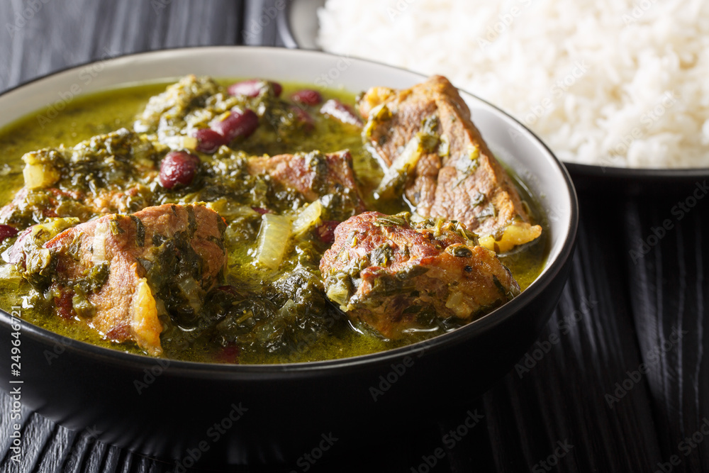 Authentic Ghormeh Sabzi dish of lamb stew meat with herbs and beans close-up in a bowl and rice. horizontal Authentic Ghormeh Sabzi dish of lamb stew meat with herbs and beans close-up in a bowl and rice. horizontal