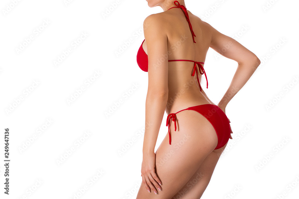 Female sexy tanned fit body in red classic bikini, side view, isolated on white