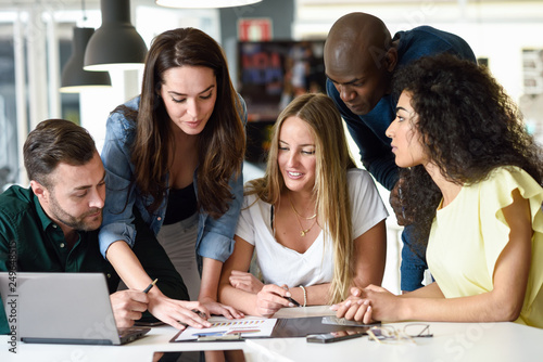 Multi-ethnic group of young men and women studying indoors.