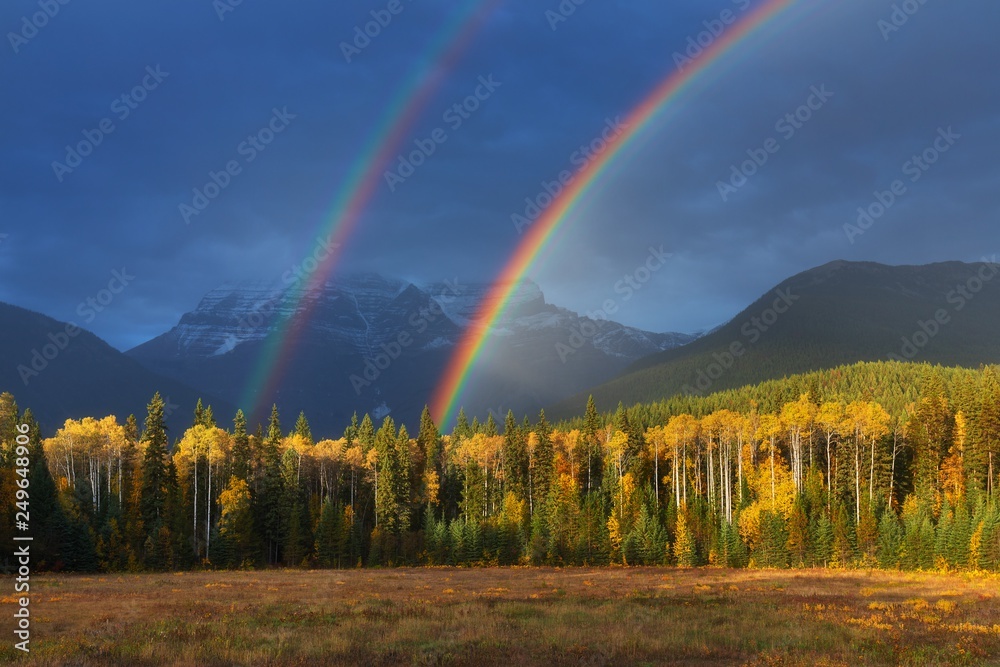 Nice summer rainbow over the mountains. Canadian Rocky Mountains, Canada. Beautiful landscape background concept