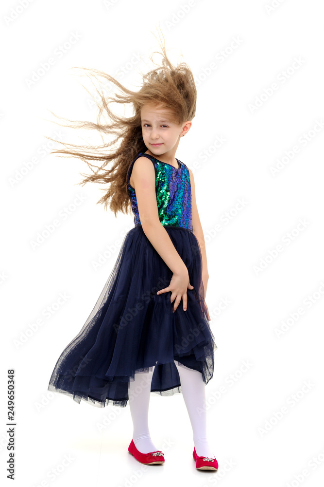 Little girl in a dress developing in the wind.