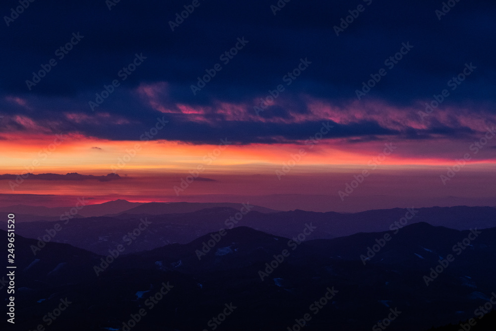 Beautifully colored sky at dusk, with mountains layers