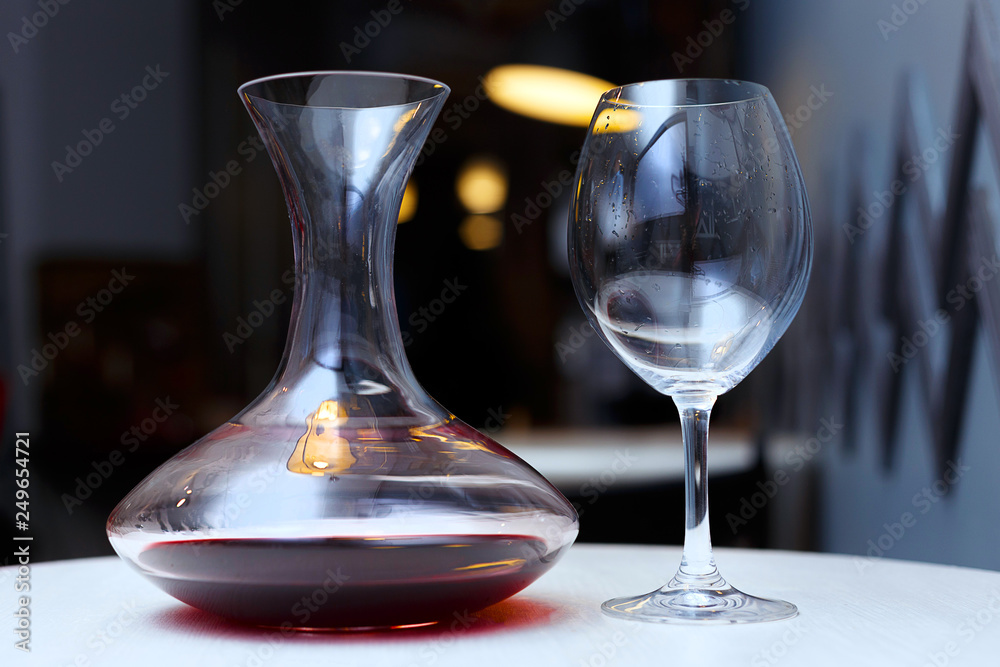 Decanter with red wine and glass on a table Decanter with red wine and glass on a table