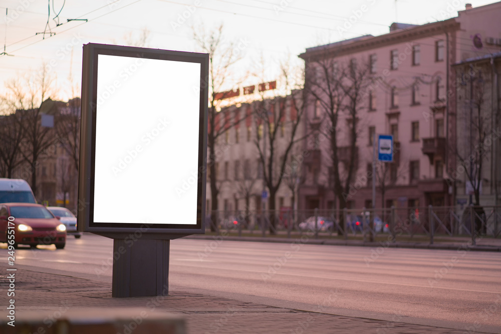 Fototapeta premium vertical billboard for posters, city format, illuminated sign near the road outdoor advertising white mockup for advertising