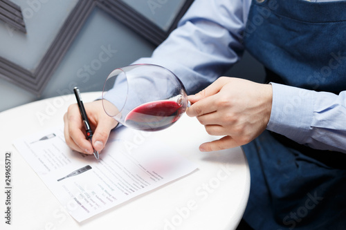 male sommelier is checking and testing red wine