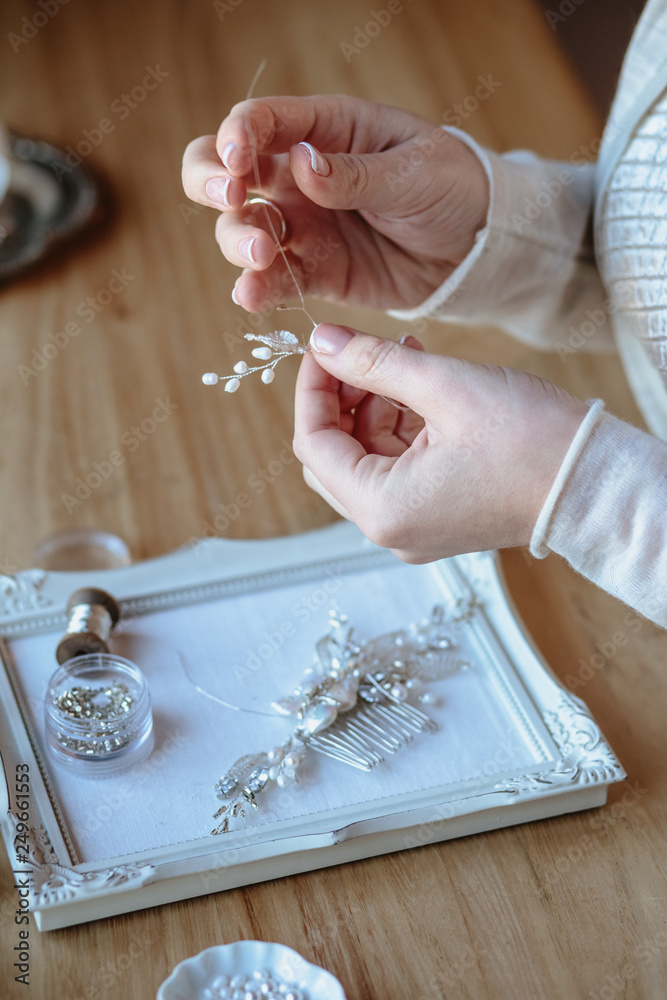 Fototapeta premium Closeup macro photo of details, workplace of decorator and creator of wedding imitation jewelry. Woman's hands in a process of creation