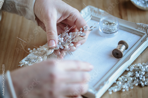 Closeup macro photo of details, workplace of decorator and creator of wedding imitation jewelry. Woman's hands in a process of creation photo