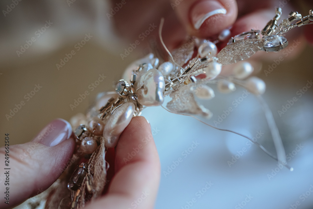 Closeup macro photo of details, workplace of decorator and creator of wedding imitation jewelry. Woman's hands in a process of creation