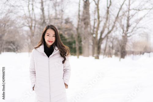 Beautiful young asian woman smiling happy for travel in snow winter season © siraphol