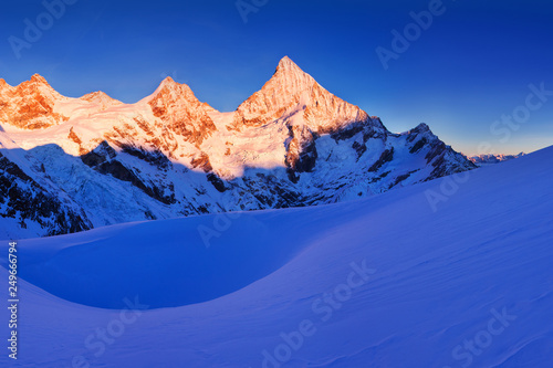 View of snow covered landscape with Dent Blanche mountains and Weisshorn mountain in the Swiss Alps near Zermatt. Panorama of the mountains in Switzerland. Beautiful morning with first snow. Christmas