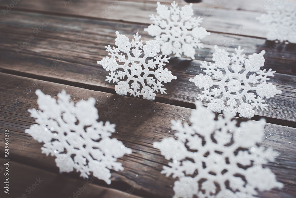 Christmas decor. White snowflakes on wooden background.	