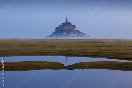 Beautiful panoramic view of famous Le Mont Saint-Michel tidal island with deep blue water and clear reflections in perfect sunny day in summer, Normandy, northern France Amazing background concept