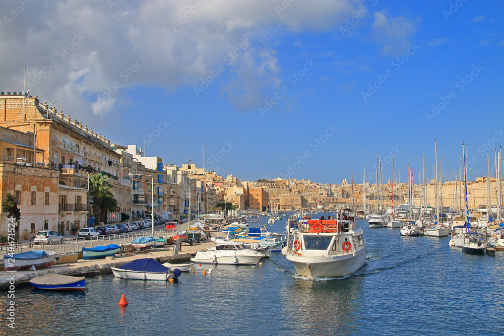 Motorboat cruise along the harbor of the island of Malta along moored yachts and boats.