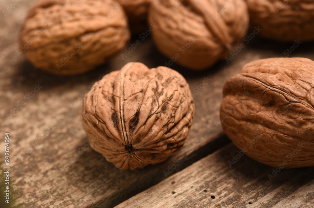 Walnut kernels and whole walnuts on rustic old oak table. Walnut kernels and whole walnuts on rustic old oak table.
