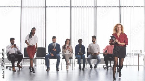 Recruits waiting for interviews for employment. Group of young businessman waiting for the start of reception sitting on chairs in lobby of an office building