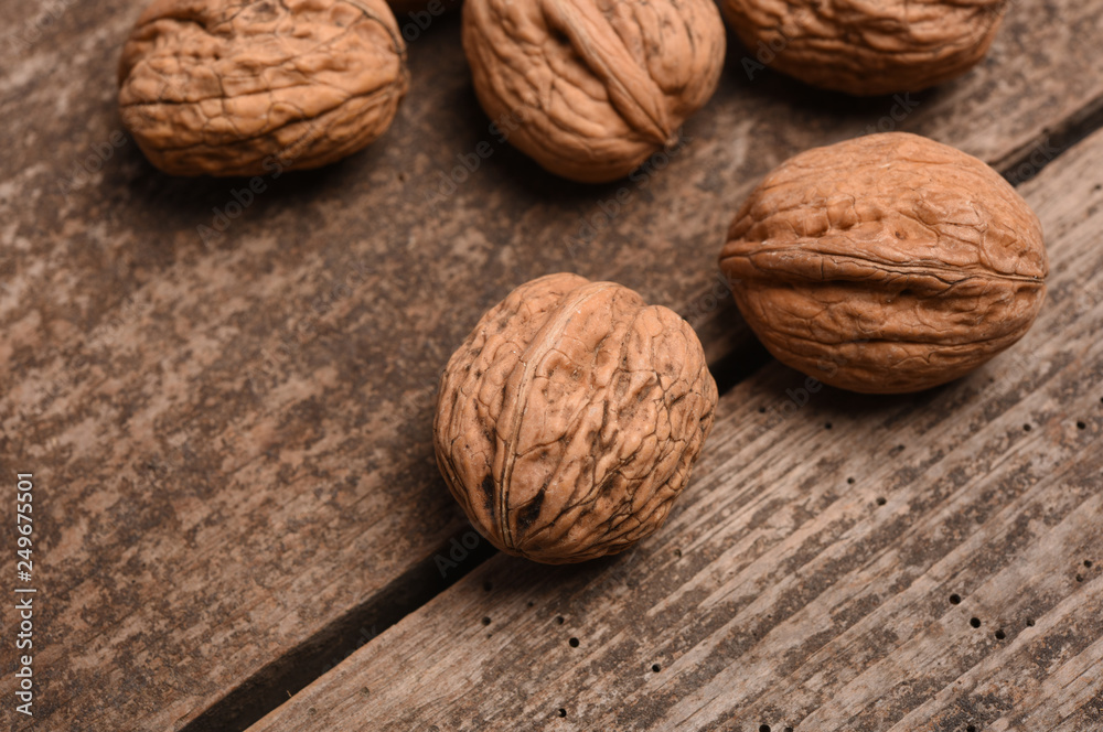 Walnut kernels and whole walnuts on rustic old oak table. Walnut kernels and whole walnuts on rustic old oak table.