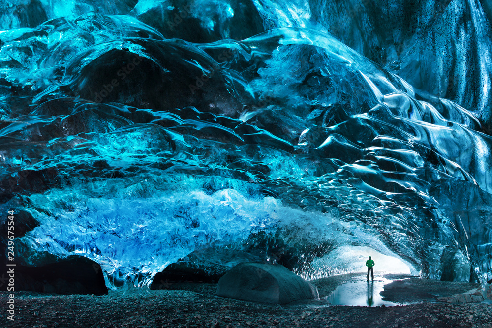 Foto Stock Man silhouette in ice cave. Blue crystal ice cave and an  underground river beneath the glacier. Amazing nature of Skaftafell,  Iceland. Vatnajokull National Park | Adobe Stock