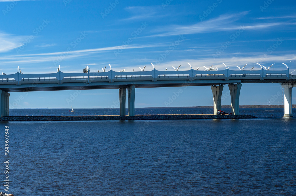 A new white cable-stayed bridge across the Neva River. Large cable-stayed bridge against the blue sea. Modern bridge construction. The central part of the WHSD. Russia. St. Petersburg A new white cable-stayed bridge across the Neva River. Large cable-stayed bridge against the blue sea. Modern bridge construction. The central part of the WHSD. Russia. St. Petersburg