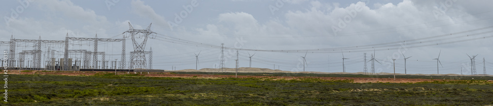 Fototapeta premium Windmills and electric trellis on a field near Atins, Brazil
