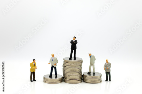 Miniature people : Businessman standing on stack of coins. Image use for business concept.