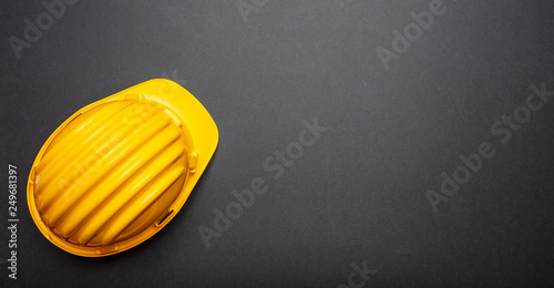 Construction project safety, Yellow hard hat on black color background, copy space
