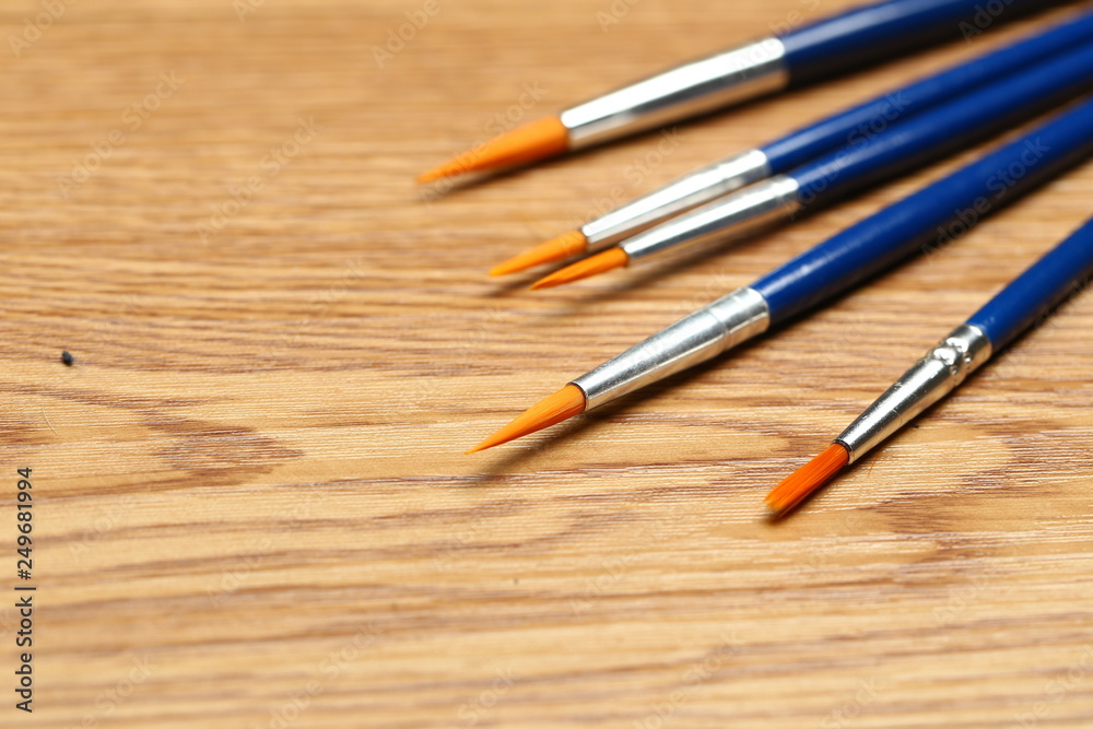 set of watercolor paintbrush on wooden beige table background