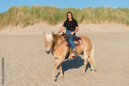 girl riding on haflinger horse on th beach