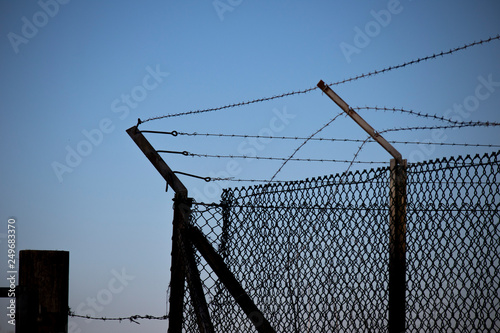 Barbed wired fence providing security to farmland in rural Hampshire