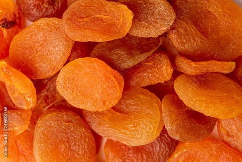 Dried apricots on dark wooden background.