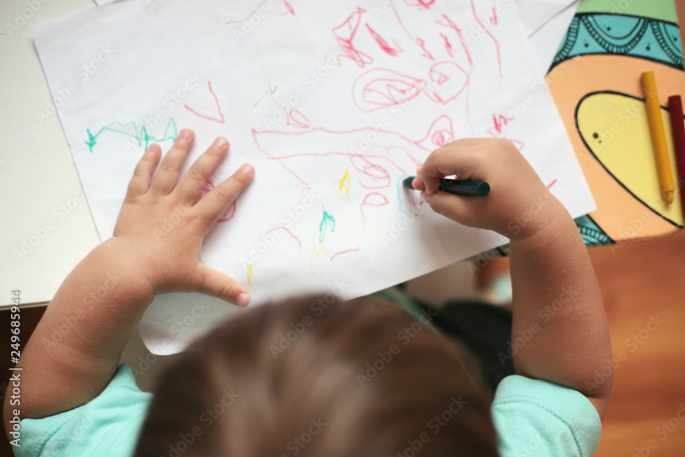 Toddler boy drawing in a table. Top view. Toddler boy drawing in a table. Top view.