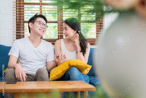 sweet lovey asian family couple sit talk good conversation on sofa in living room house background