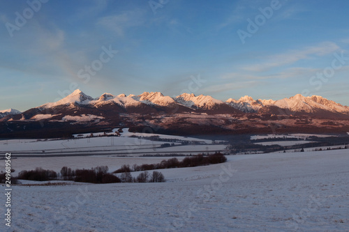 Panoramic view of beautiful winter wonderland mountain scenery in evening light at sunset. Carpathian mountains above the clouds. Christmas and New year. 