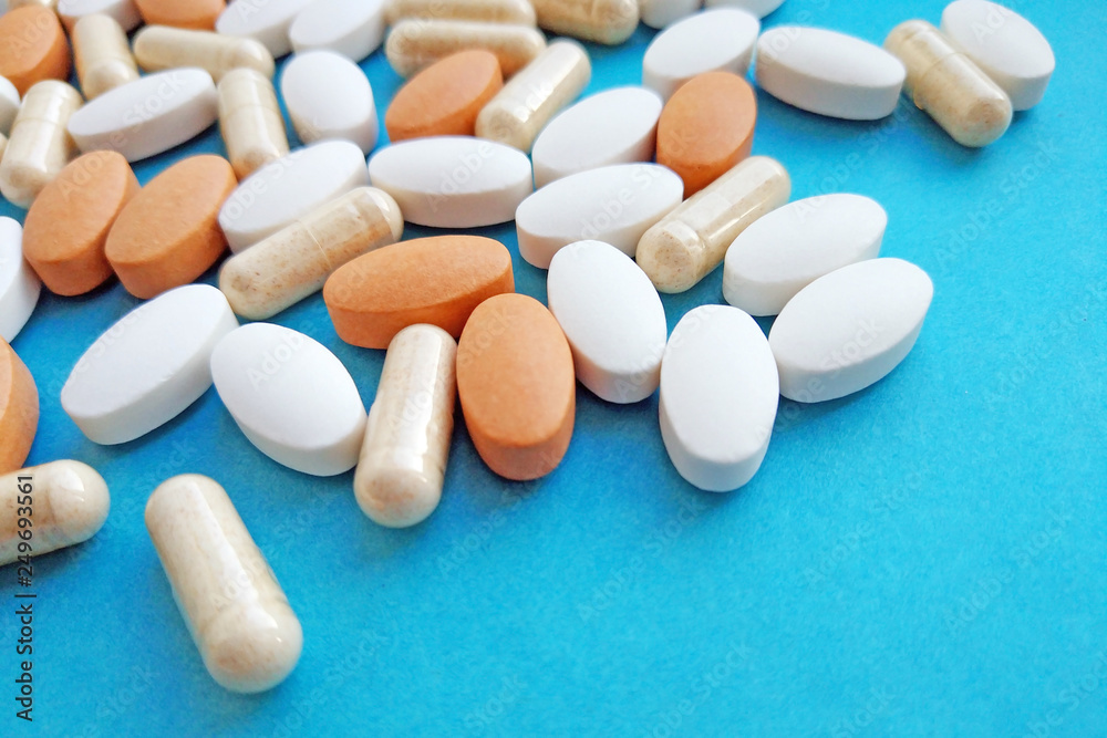 Pharmaceutical pills, tablets and capsules on blue background. Medicine concept, pharmacy, treatment and drugs prescription theme