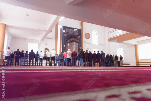 Religious muslim prayers praying together inside the big mosque.
