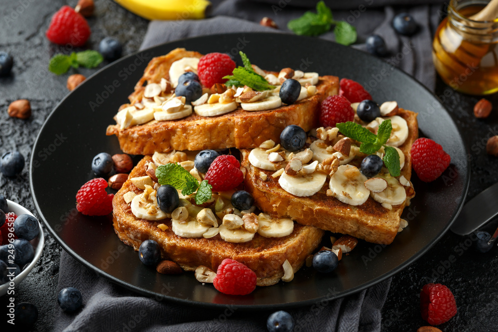 French cinnamon toast with blueberries, raspberries, banana, nuts, hazelnut and honey. French cinnamon toast with blueberries, raspberries, banana, nuts, hazelnut and honey.