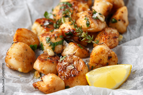 Scallops seared in garlic and parsley butter served on crumpled paper